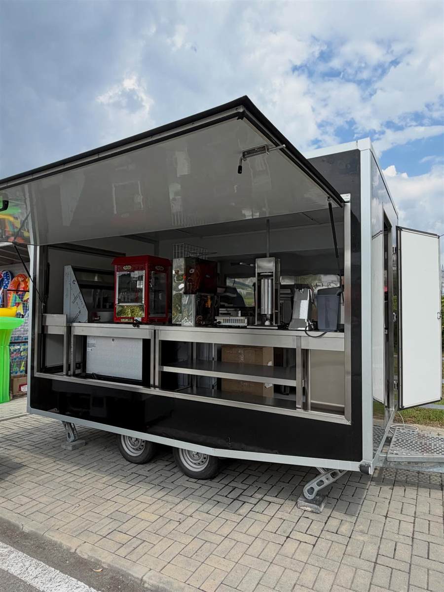Black street-food trailer with open serving hatch