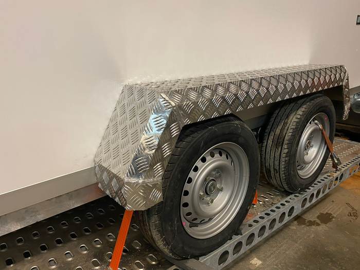 Checker-plate mudguard on a platform trailer